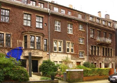 Moltkeviertel Essen: Häuserzeile am nördlichen Moltkeplatz mit Bronze-Stele von Jo Schöpfer, Aussenarbeit "Blaues Pigment" von Katja Hajek und gelber Spray-Banane von Thomas Baumgärtel