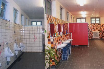 Mädchen-WC vor und nach der Sanierung in betont farbenfroher Optik
