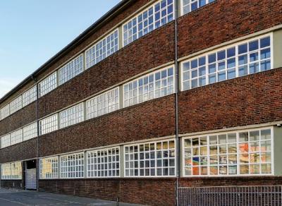 ehemalige Lagerhalle mit Fensterbändern und Ziegelmauerwerk