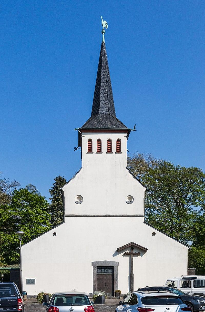Frontansicht mit Portal, Missionskreuz und Kirchturm mit Knickhelm