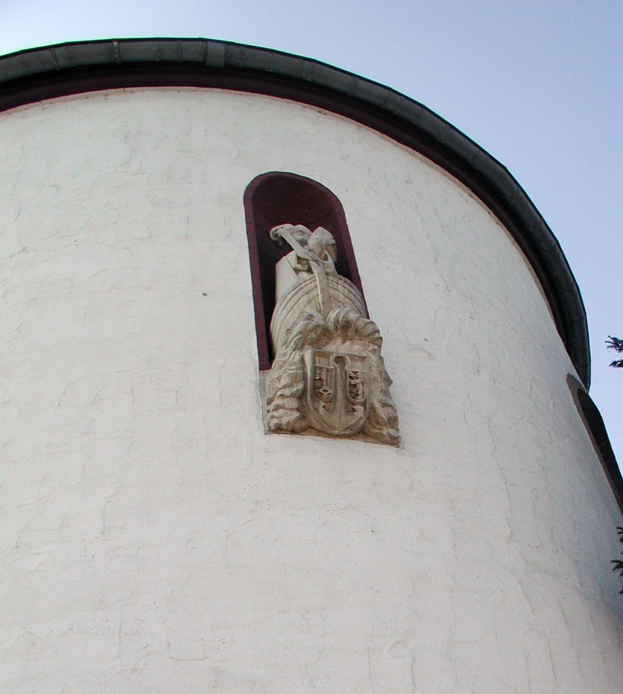 Nische der äußeren Chorwand, figürliche Darstellung des hl. Maternus am Steuerruder eines Schiffes, darunter das Rodenkirchener Wappen