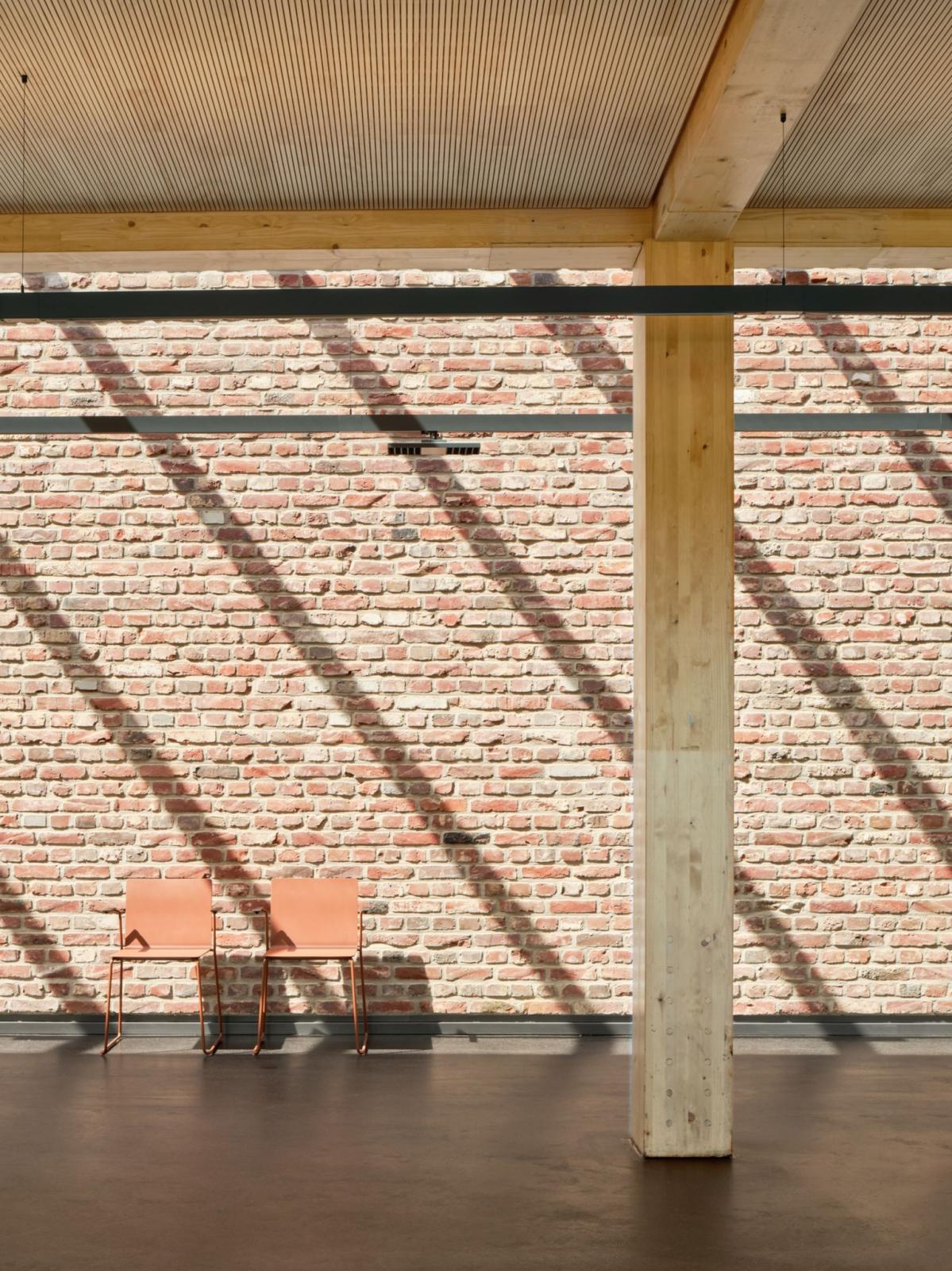 Materialkontrast der Holzkonstruktion und backsteinsichtigen Betonwand