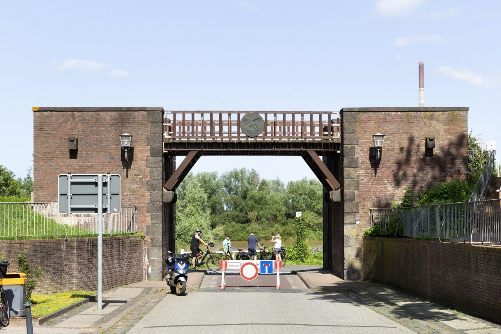 Frontansicht mit Straßendurchführung und Deichbrücke