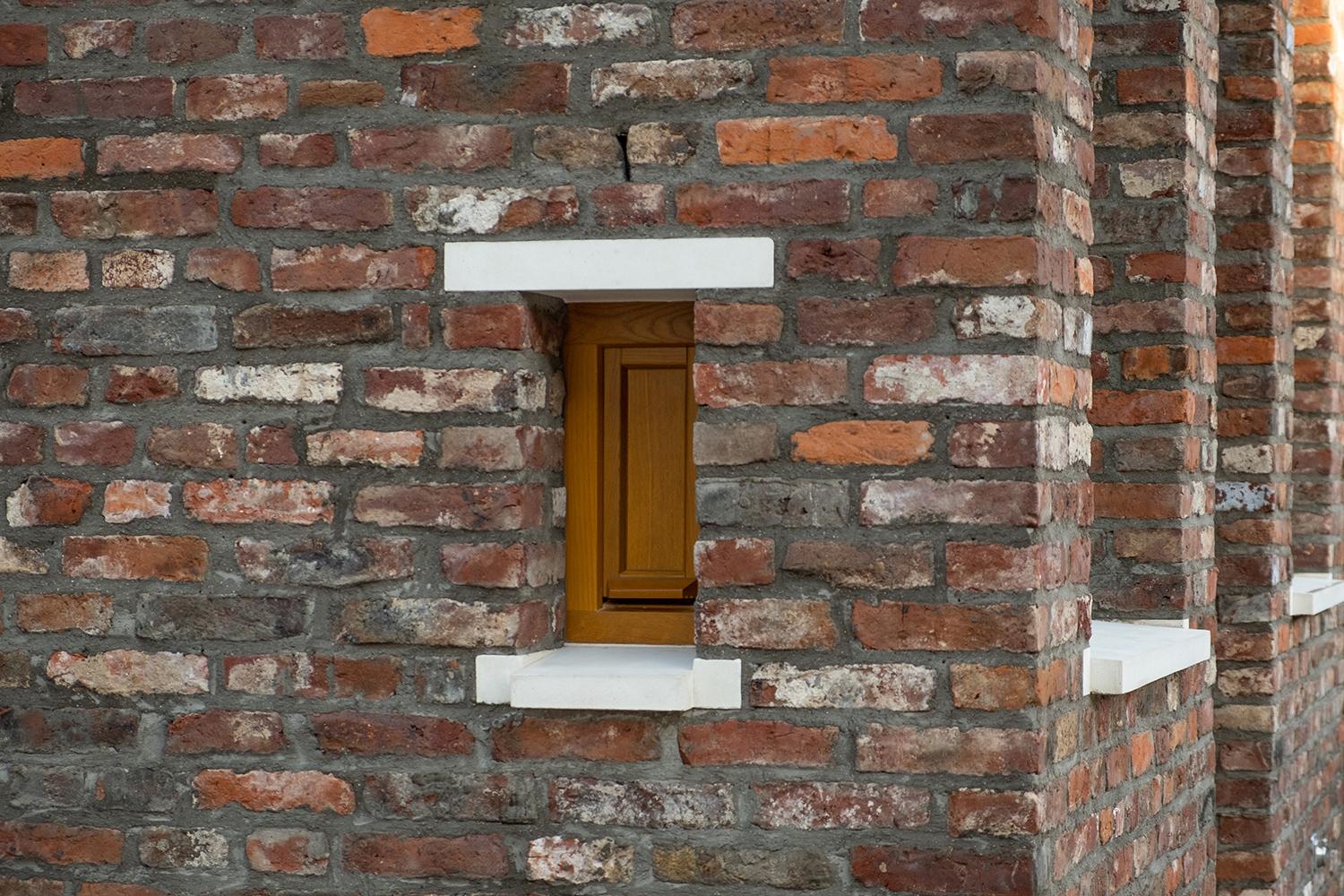 Detailansicht Mauerwerk mit holzsichtiger Lüftungsöffnung