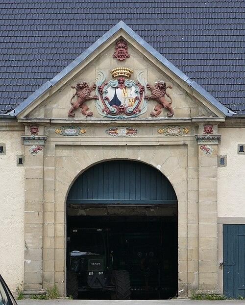Schloss Körtlinghausen, Portal mit Tordurchfahrt des Wirtschaftsgebäudes, Familienwappen