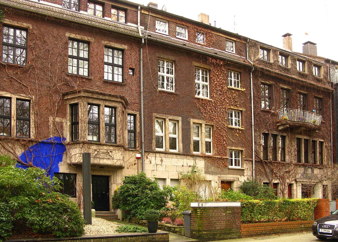 Moltkeviertel Essen: Häuserzeile am nördlichen Moltkeplatz mit Bronze-Stele von Jo Schöpfer, Aussenarbeit "Blaues Pigment" von Katja Hajek und gelber Spray-Banane von Thomas Baumgärtel