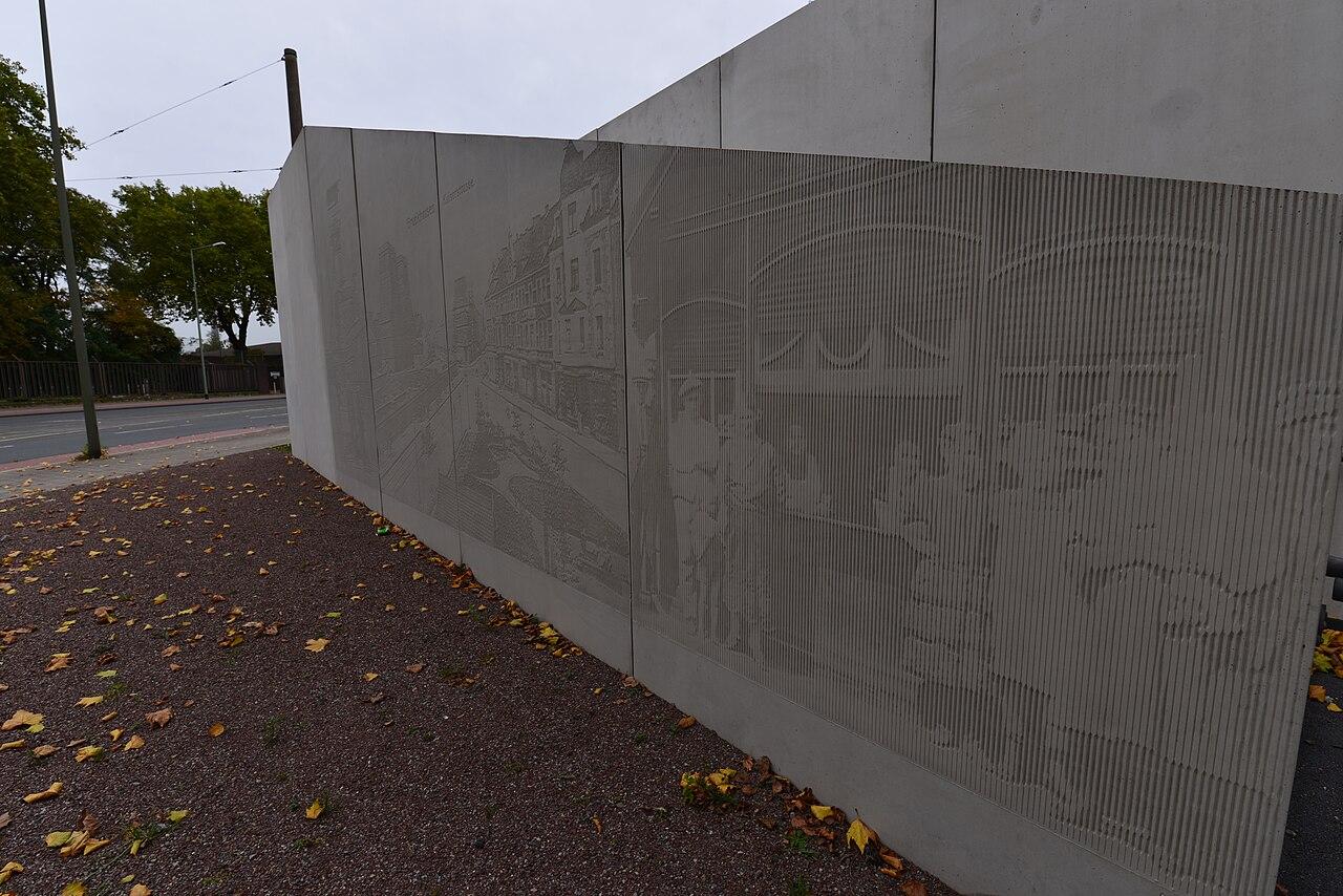 Sichtbetonwand mit Relief einer historischen Fotografie 