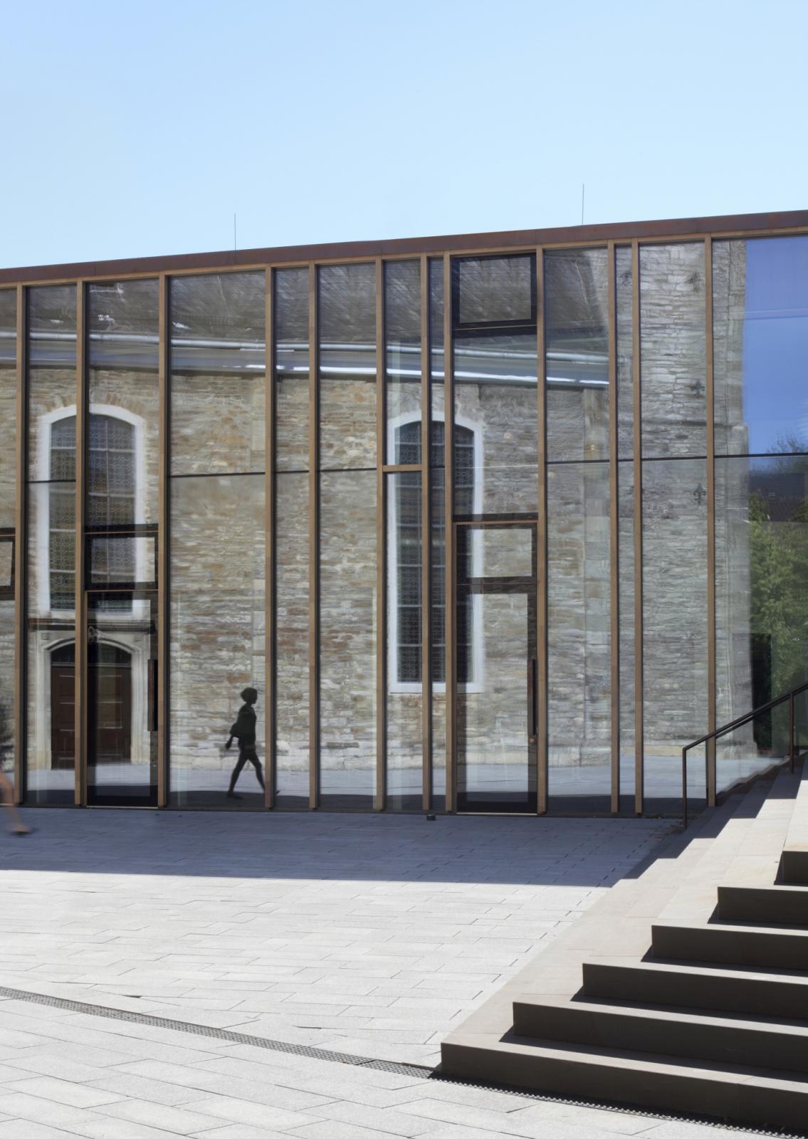 Spiegelung der Kirche in der Fassade des Gemeindezentrums
