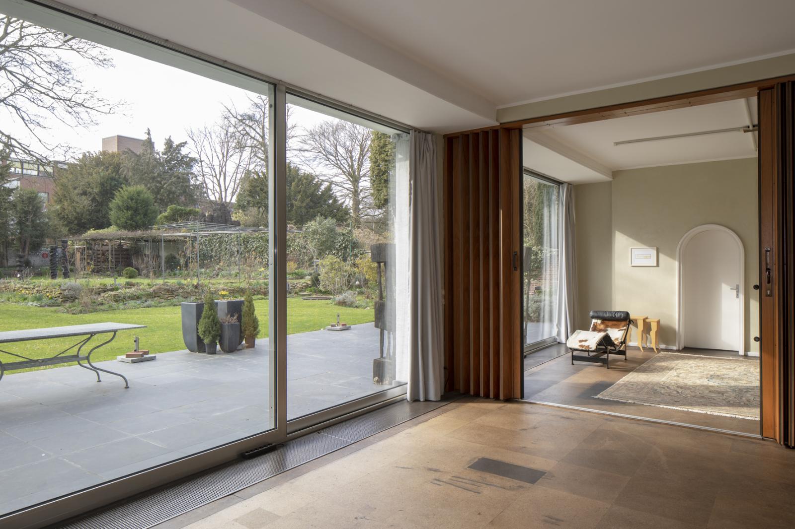 Innenansicht mit Blick durch die Fenster auf Terrasse und Garten