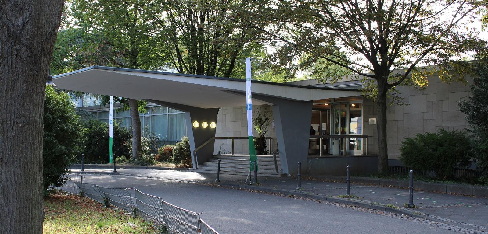 seitliche Ansicht des Eingangsbereichs mit weit auskragendem Betonvordach